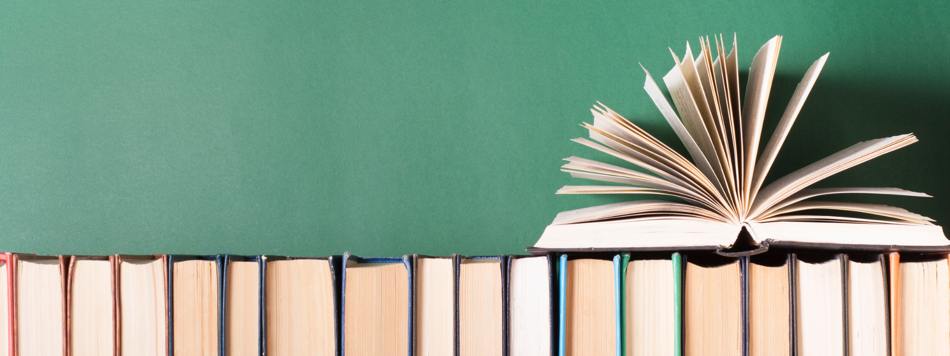 Books on a shelf with one open book